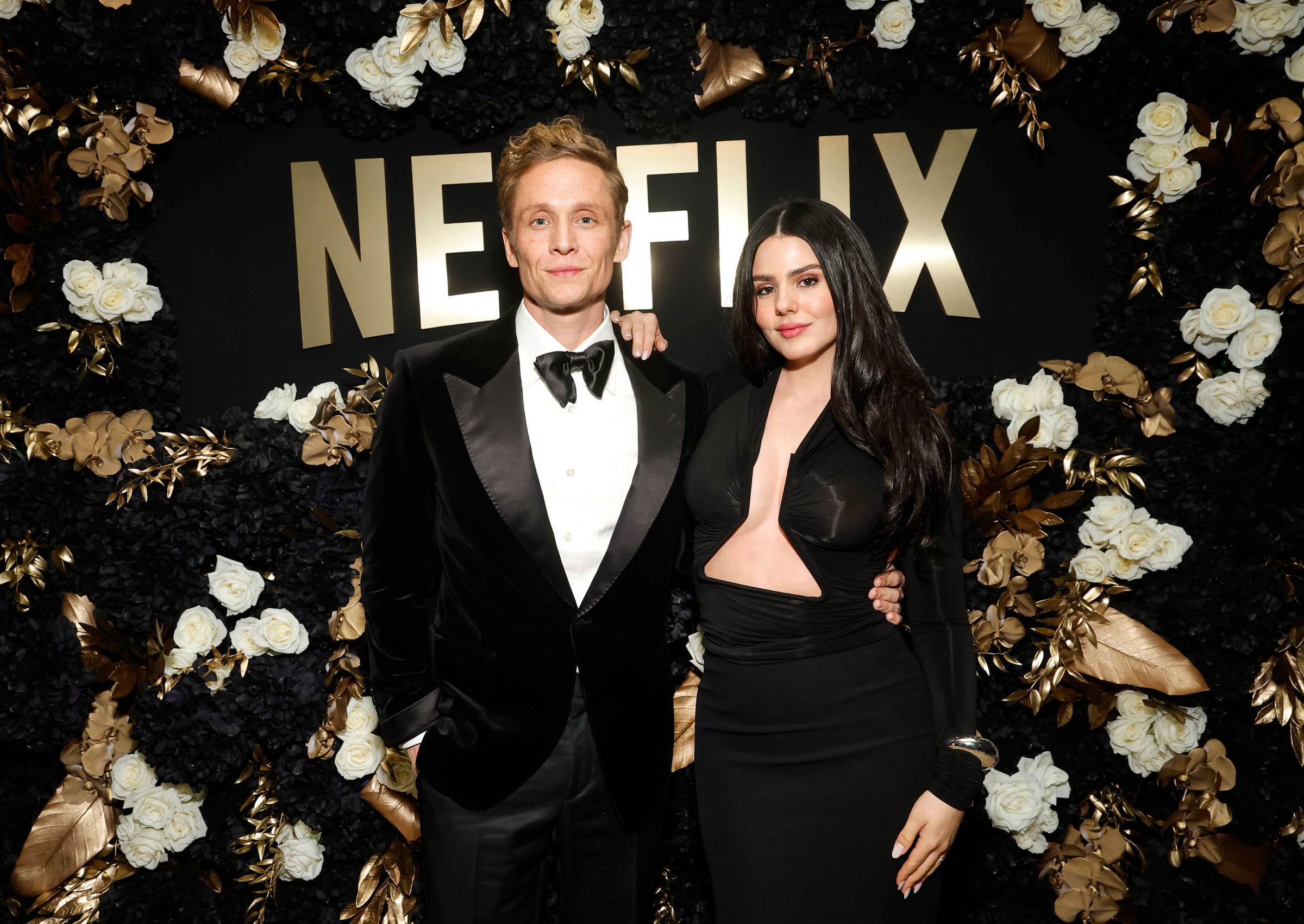 Die Schauspieler Matthias Schweighöfer und Ruby O. Fee posieren in Abendgarderobe vor einem Banner des Streamingdienstes Netflix