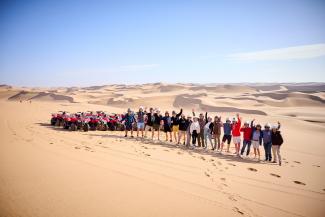 Playboy-Gentlemen's-Adventure-Tour-Gruppe vor Quads in der Wüste