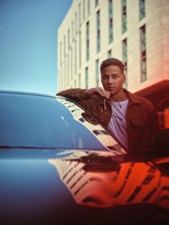 „How to be a Man“-Coverstar Tom Wlaschiha lehnt am Alfa Romeo